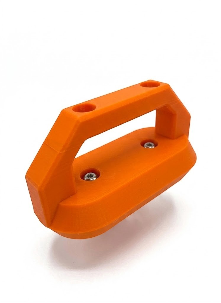 Cold Composites orange MagLug magnetic handle with two screw holes and silver screws.