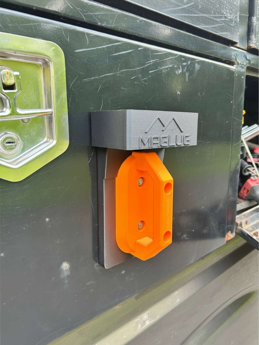 Cold Composites MagLug Workstation Lite magnetic tool holder in matte black and orange mounted on a steel surface.