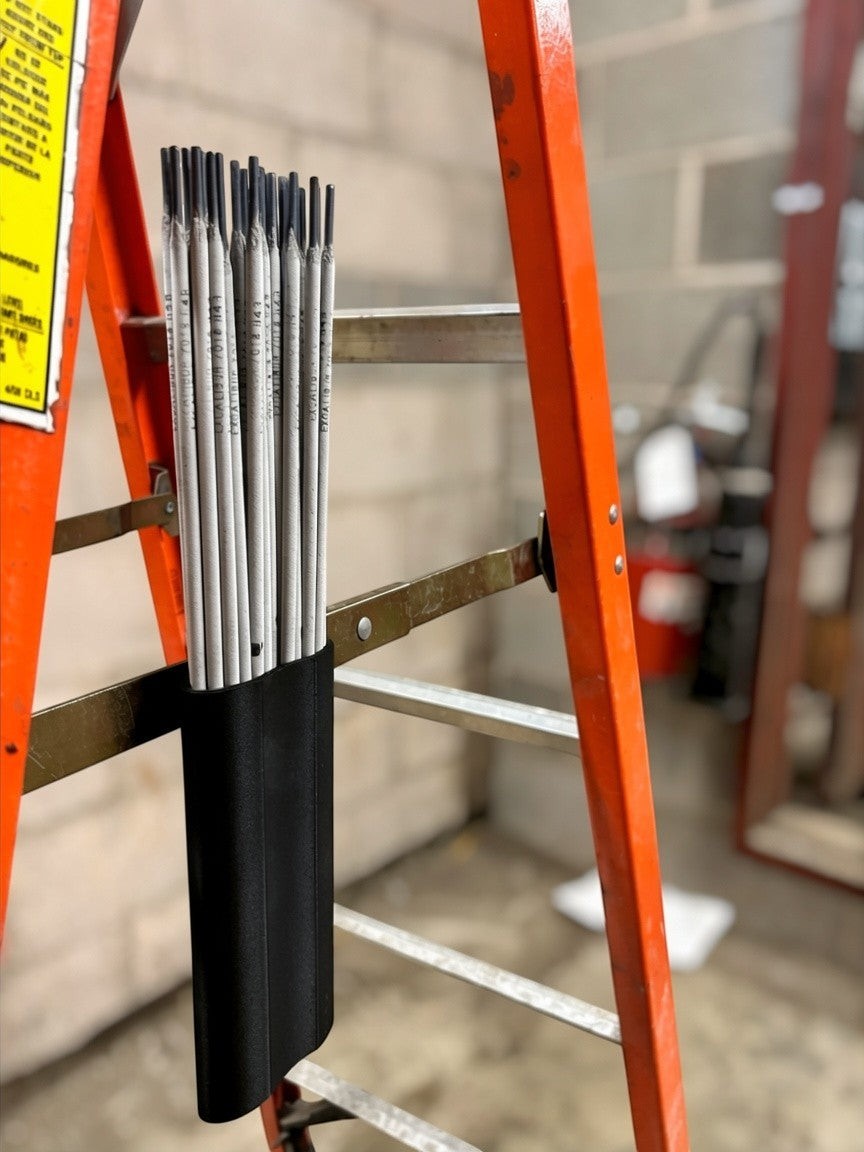 Cold Composites MagLug welding rod pouch with belt clip, black composite, holding welding rods on an orange ladder.